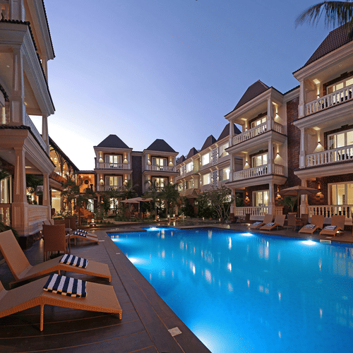 A full view of the Grand Continent, Anjuna - A Sarovar Portico Affiliate Hotel  with buildings and in between swimming pool.